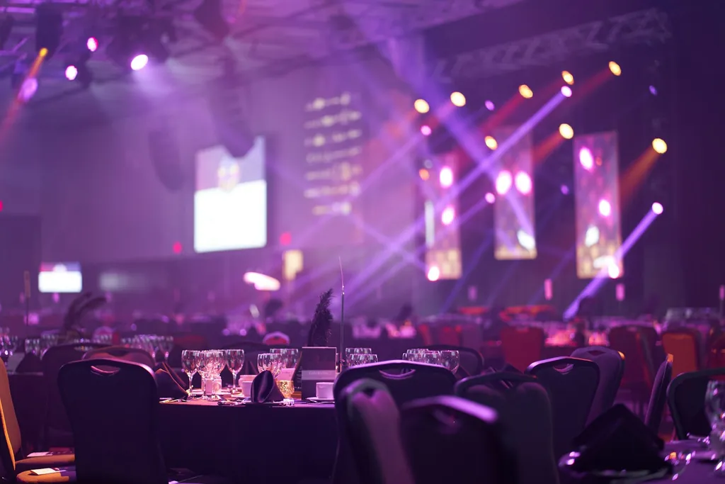 Evento con luces de escenario y mesas (imagen conceptual)
